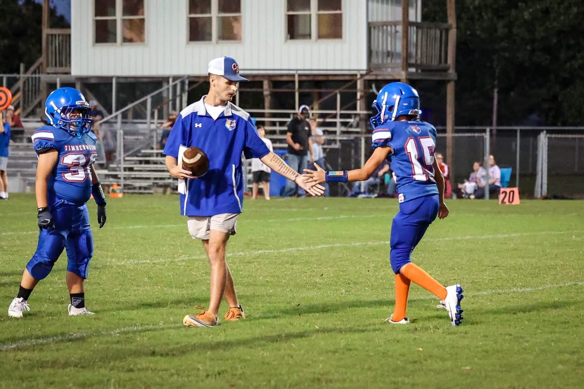 Austin Creamer coaching young athletes on the football field